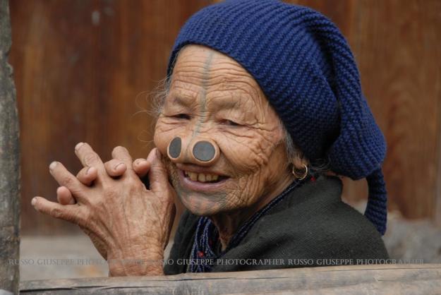 Le donne Apatani hanno il volto ampiamente tatuato (Twpe) con linee blu dalla fronte fino alla punta del naso e cinque strisce verticali sotto il labbro inferiore nel mento