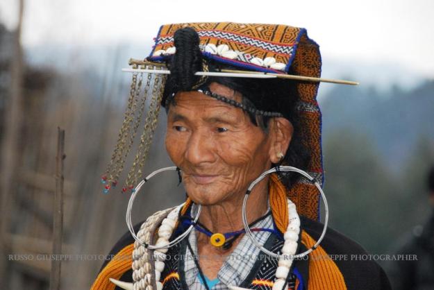 Lo sciamano è vestito con il Jilan, l'abito cerimoniale tradizionale e con grossi orecchini ai lobi